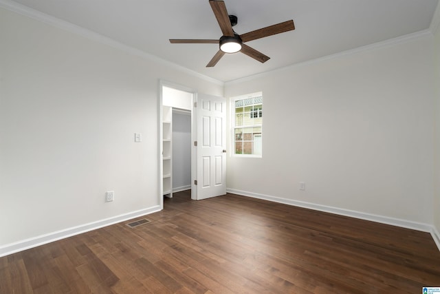 unfurnished bedroom featuring visible vents, crown molding, dark wood finished floors, and baseboards