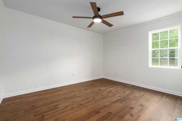 spare room with visible vents, baseboards, ornamental molding, dark wood finished floors, and a ceiling fan