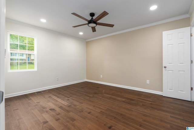 empty room featuring dark wood-type flooring, visible vents, a ceiling fan, and crown molding