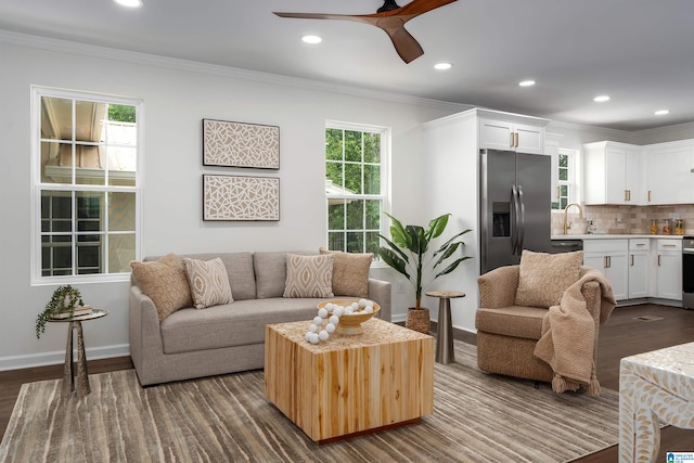 living room with dark wood finished floors, recessed lighting, ornamental molding, baseboards, and a ceiling fan