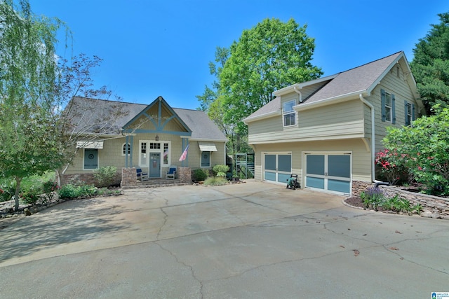 craftsman inspired home featuring concrete driveway, stone siding, and a garage
