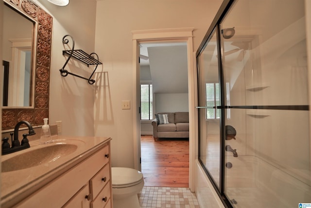 full bath with toilet, enclosed tub / shower combo, and vanity