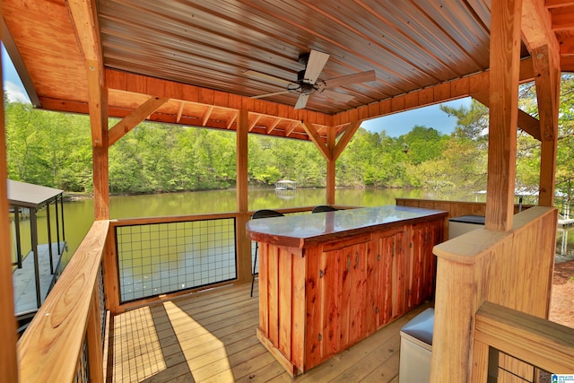 deck featuring outdoor dry bar, a water view, and ceiling fan