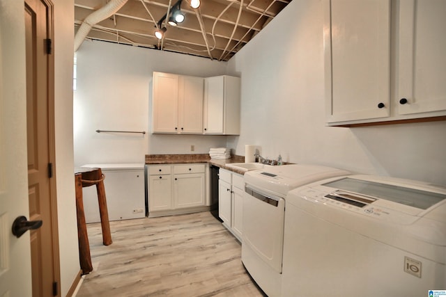 laundry room with a sink, cabinet space, independent washer and dryer, and light wood-style floors