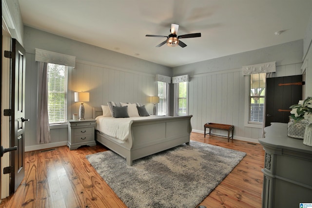 bedroom with baseboards, ceiling fan, and light wood-style floors