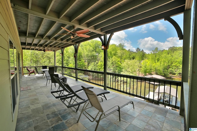 view of patio / terrace featuring a wooded view and a ceiling fan