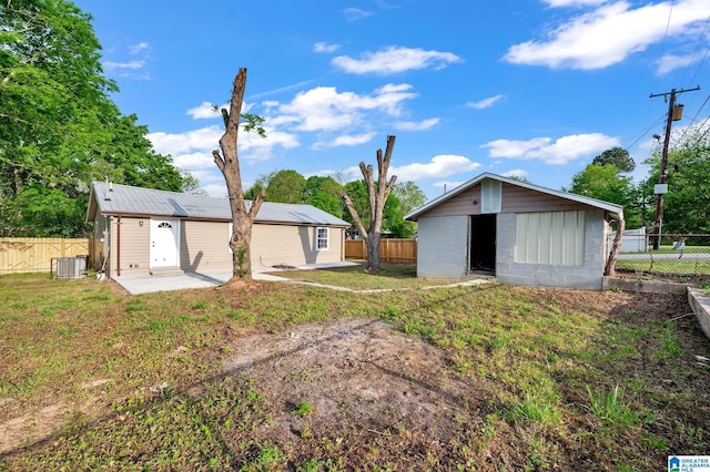 300 6th St, Docena, AL 35060 - back of house with an outdoor structure, central air condition unit, a yard, and a fenced backyard