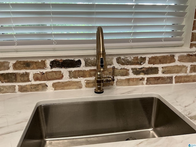 details with a sink and light stone countertops