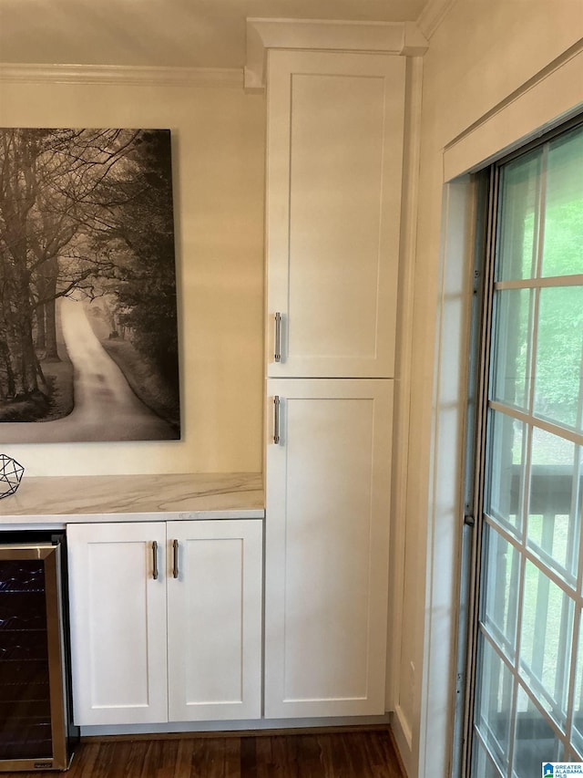 details featuring crown molding, beverage cooler, and wood finished floors