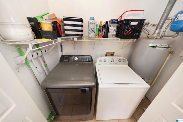 laundry area with tile patterned flooring, water heater, washer and dryer, and laundry area