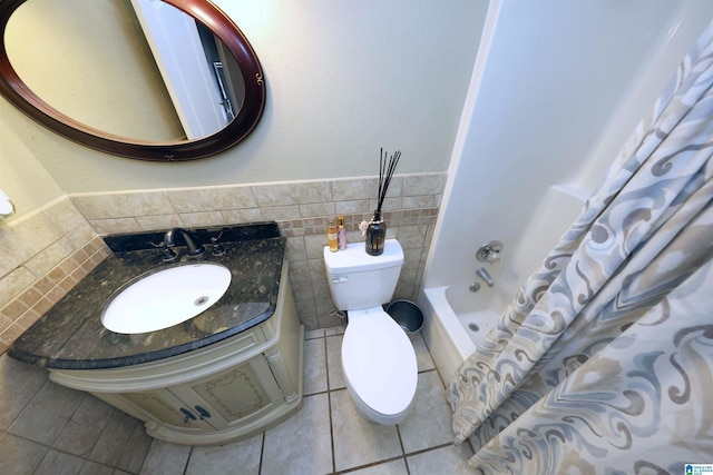 bathroom with tile patterned floors, toilet, tile walls, shower / bath combo with shower curtain, and vanity