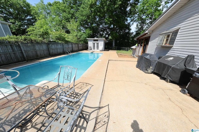 view of pool featuring a patio area, a fenced backyard, an outdoor structure, and a fenced in pool