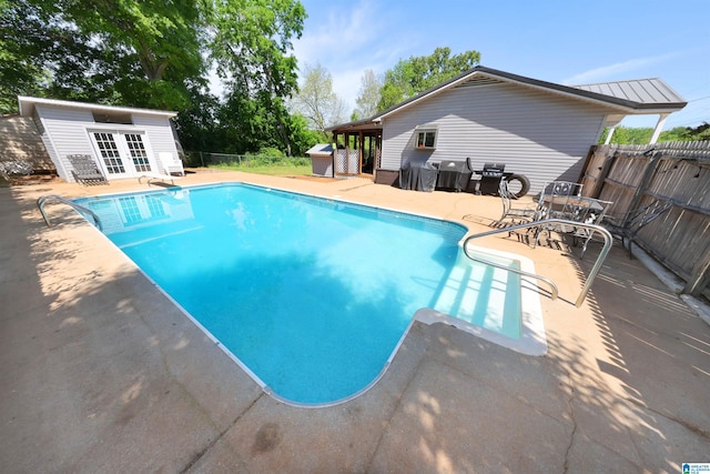 view of swimming pool featuring a fenced backyard, a patio, a fenced in pool, and french doors