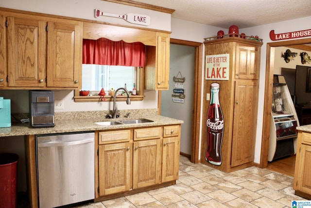 kitchen featuring light stone countertops, a textured ceiling, stainless steel dishwasher, and a sink