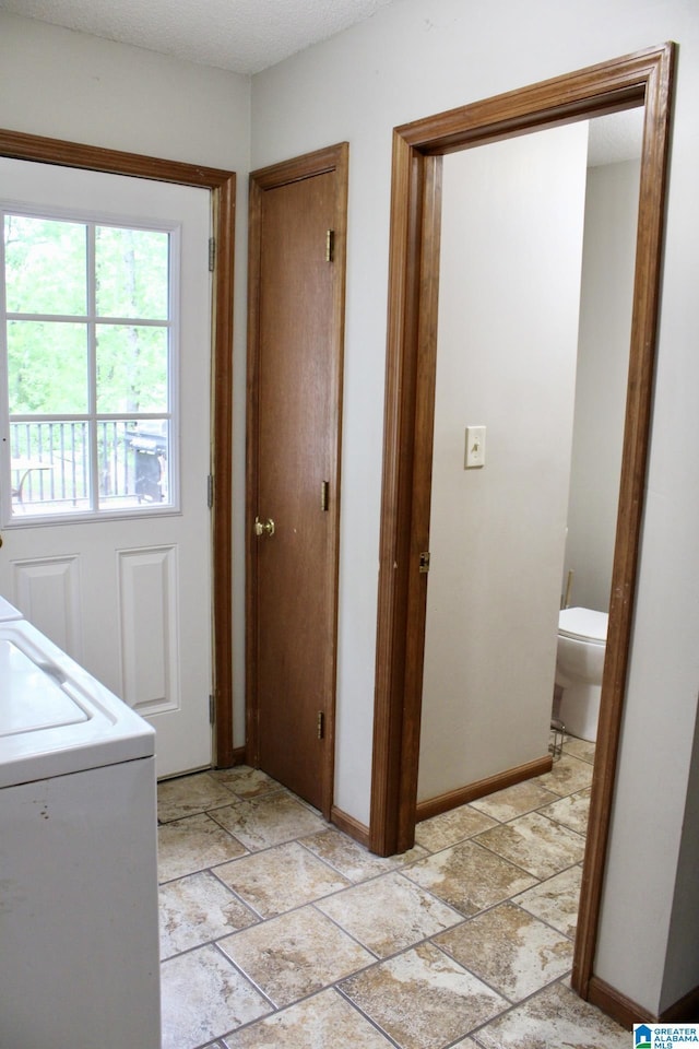 laundry room with washer / dryer, stone finish floor, laundry area, and baseboards