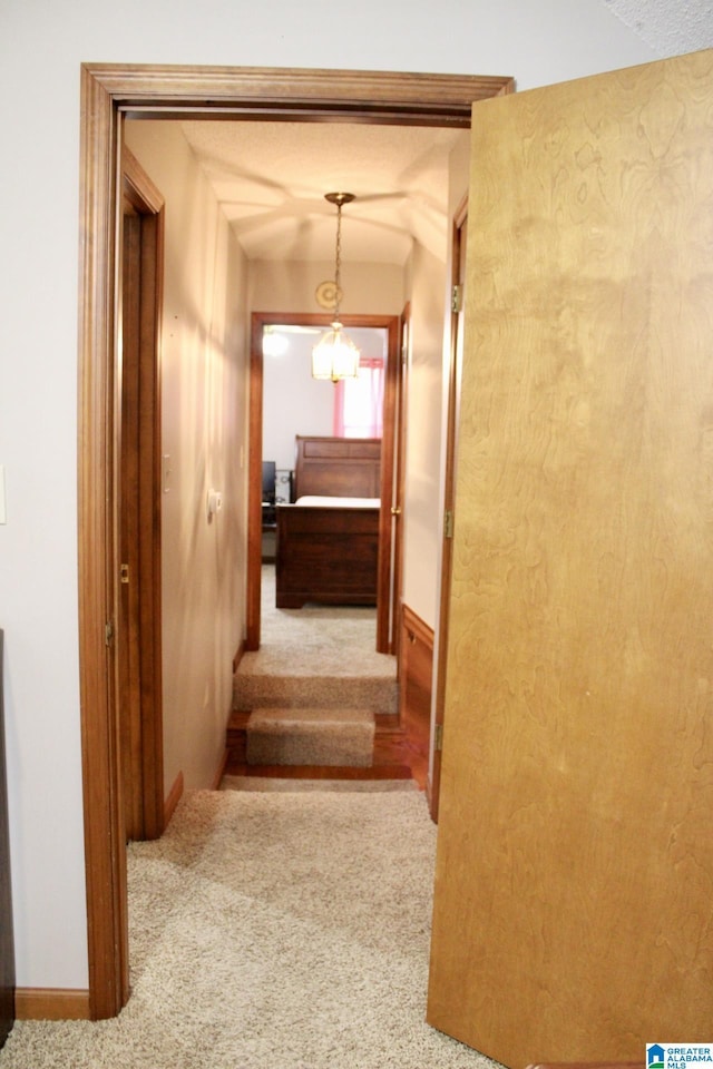 staircase with baseboards, vaulted ceiling, and carpet floors