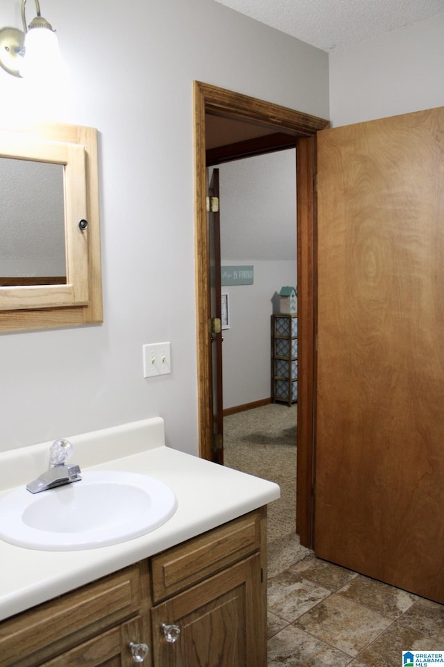bathroom featuring a textured ceiling and vanity