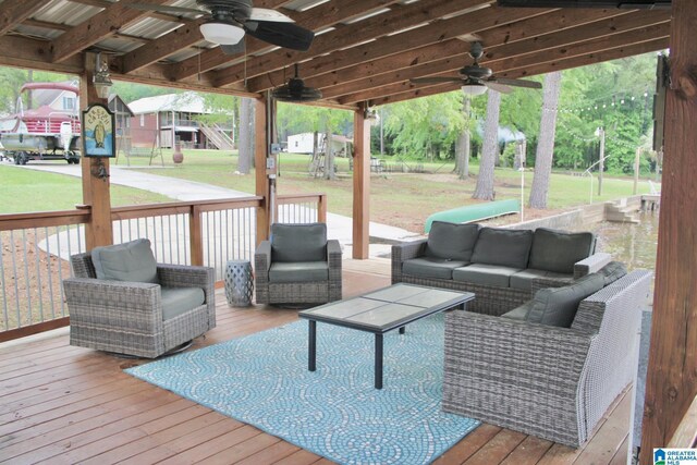 wooden terrace with ceiling fan, a yard, and outdoor lounge area