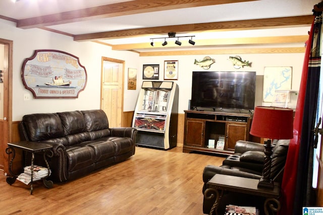 living area with beam ceiling and wood finished floors