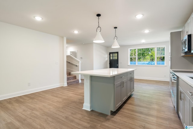 1515 Spring St, Alexander City, AL 35010 - kitchen featuring light countertops, a center island, baseboards, gray cabinetry, and appliances with stainless steel finishes