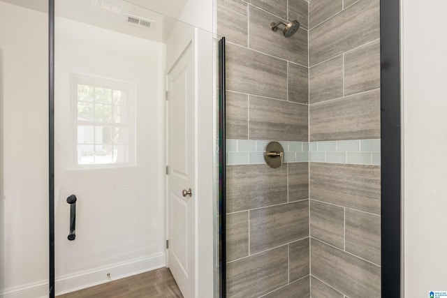 1515 Spring St, Alexander City, AL 35010 - full bath with wood finished floors, visible vents, and tiled shower