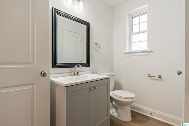1515 Spring St, Alexander City, AL 35010 - bathroom featuring baseboards, toilet, vanity, and wood finished floors