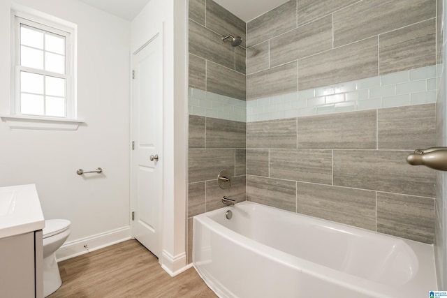1515 Spring St, Alexander City, AL 35010 - bathroom featuring washtub / shower combination, wood finished floors, toilet, vanity, and baseboards