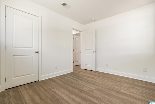 1515 Spring St, Alexander City, AL 35010 - unfurnished bedroom with baseboards, wood finished floors, and visible vents