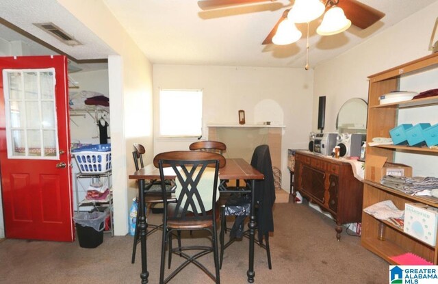 801 Walnut St, Talladega, AL 35160 - carpeted dining area with visible vents and a ceiling fan