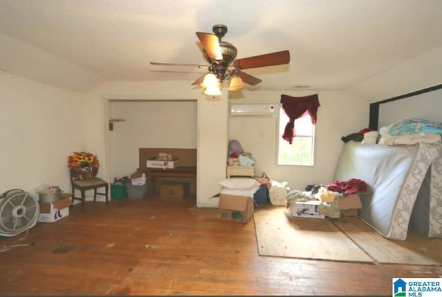 801 Walnut St, Talladega, AL 35160 - bedroom featuring hardwood / wood-style floors, vaulted ceiling, a wall unit AC, and a ceiling fan