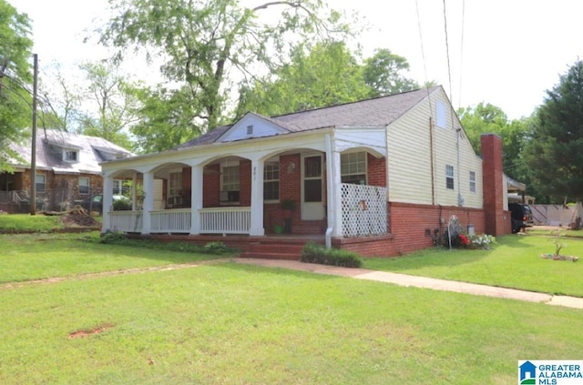801 Walnut St, Talladega, AL 35160 - view of front of property featuring a porch, brick siding, and a front yard