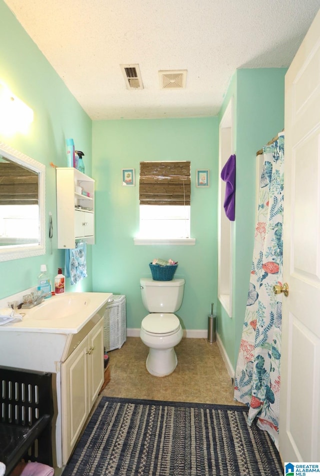 801 Walnut St, Talladega, AL 35160 - full bath with toilet, visible vents, and plenty of natural light