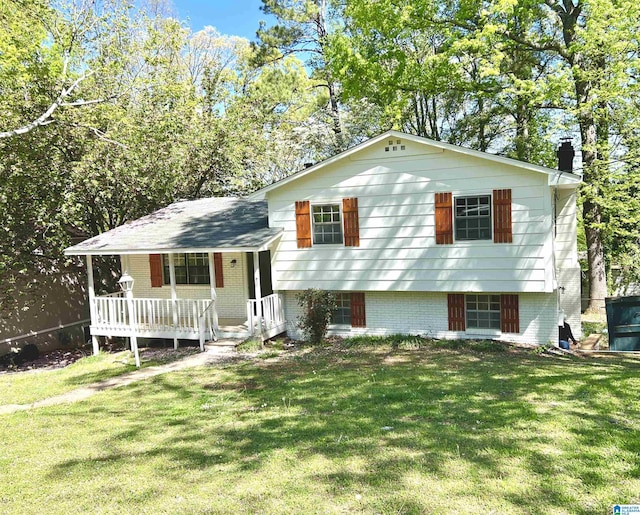 split level home featuring a front yard, a porch, and brick siding