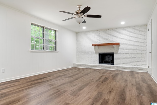 unfurnished living room with baseboards, ceiling fan, wood finished floors, and a fireplace