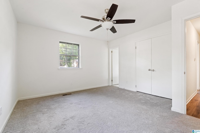 unfurnished bedroom featuring carpet floors, baseboards, a closet, and visible vents