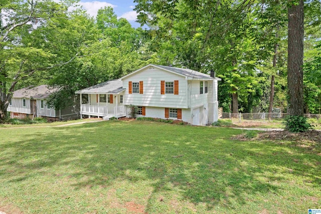 split level home featuring a garage, fence, a front yard, a chimney, and a porch