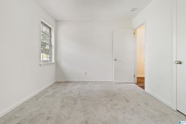 empty room with baseboards and carpet