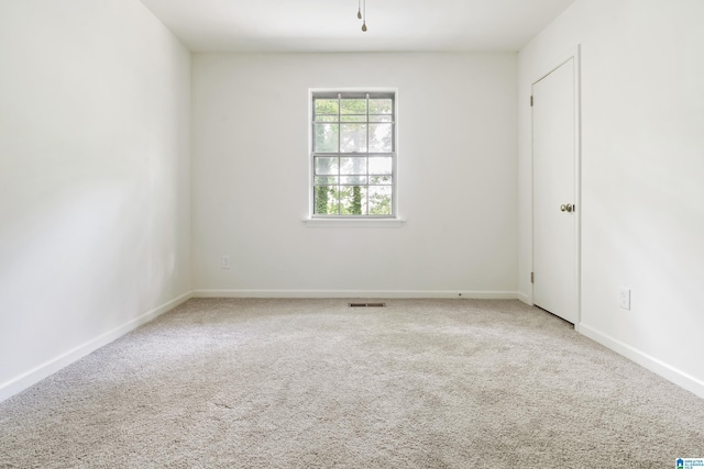 empty room featuring visible vents, baseboards, and carpet floors