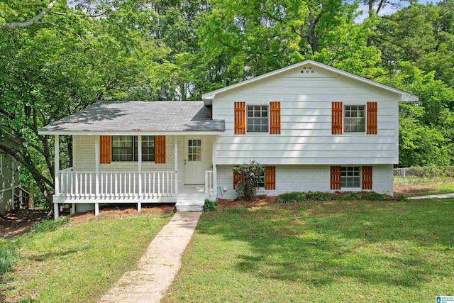 split level home with brick siding, a front lawn, and covered porch