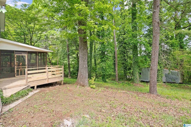 view of yard featuring a sunroom and a deck