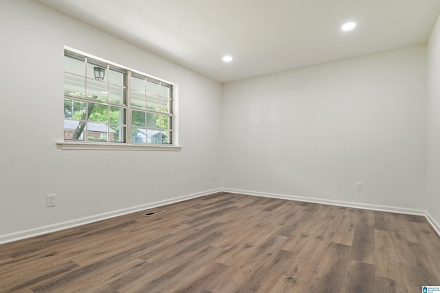 spare room with visible vents, recessed lighting, baseboards, and wood finished floors
