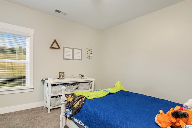 bedroom featuring baseboards, visible vents, light carpet, and multiple windows