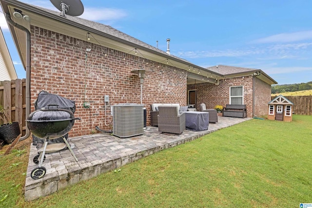 back of house with a yard, brick siding, fence, central air condition unit, and a patio