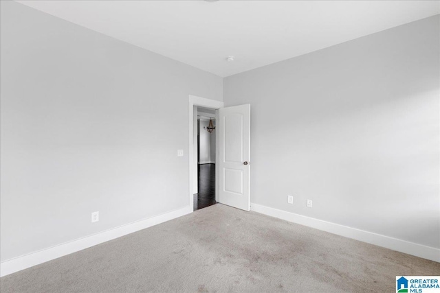 carpeted empty room with baseboards