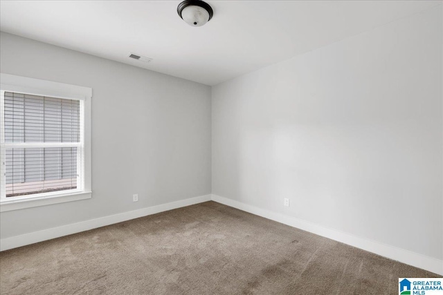 carpeted empty room featuring visible vents and baseboards