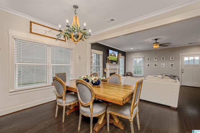 dining room with a fireplace, visible vents, ornamental molding, and dark wood-type flooring