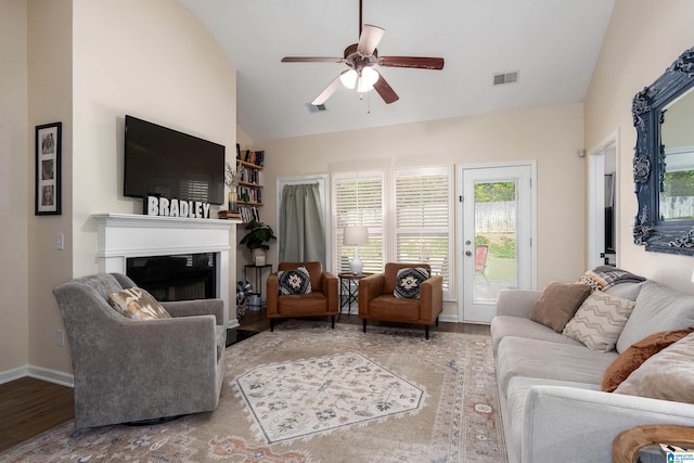 living area with visible vents, wood finished floors, ceiling fan, and a fireplace