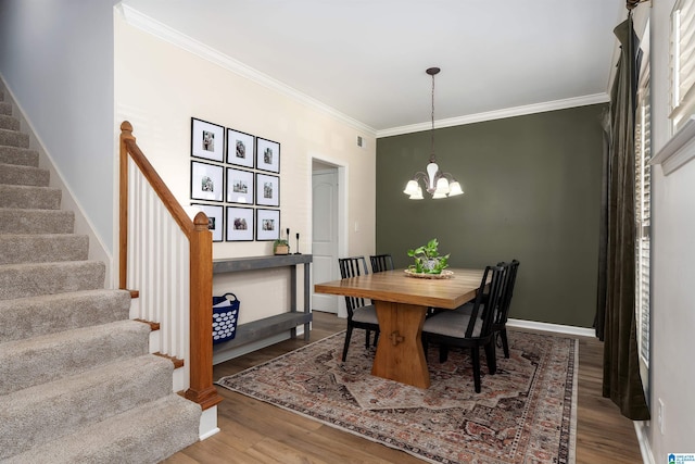 dining room featuring an inviting chandelier, stairway, wood finished floors, and crown molding