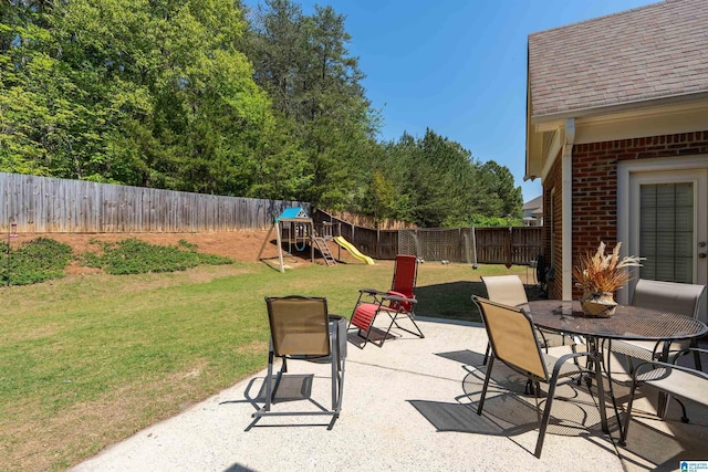 view of patio featuring outdoor dining space, a playground, and a fenced backyard