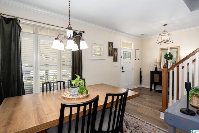 dining area with wood finished floors, ornamental molding, baseboards, stairway, and a notable chandelier